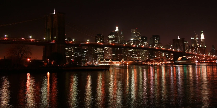 a bridge over the water leading to some very tall buildings