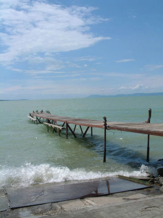 a large pier with benches next to the ocean