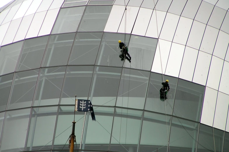 a couple of people hanging from strings by some wire