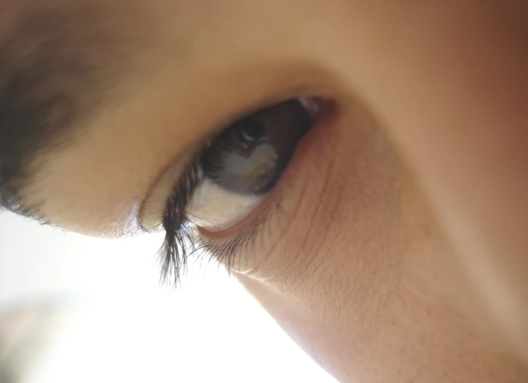 a young man's eye with his reflection in the background