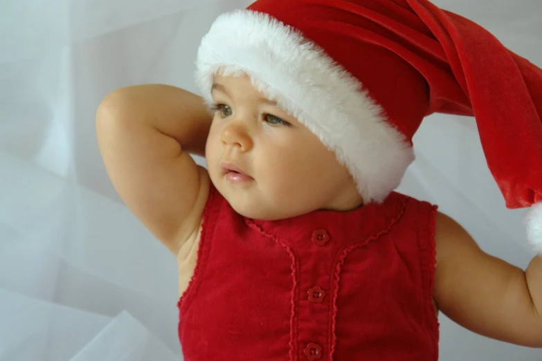 a baby girl wearing a santa hat on top of her head