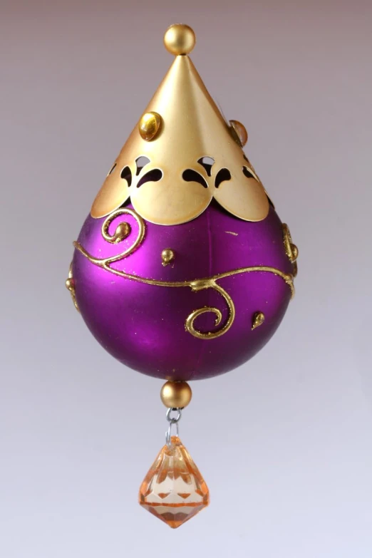 an ornament of purple and gold with an ornate design