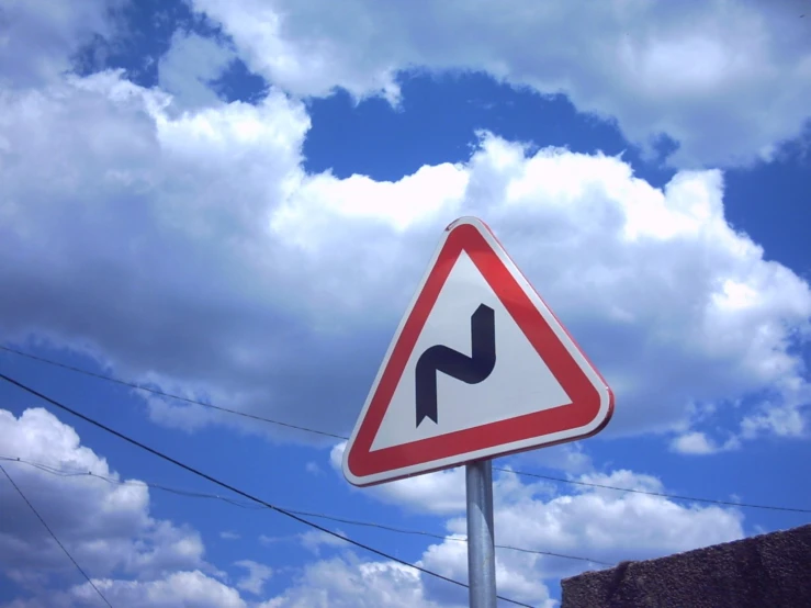 street sign next to power lines under partly cloudy sky