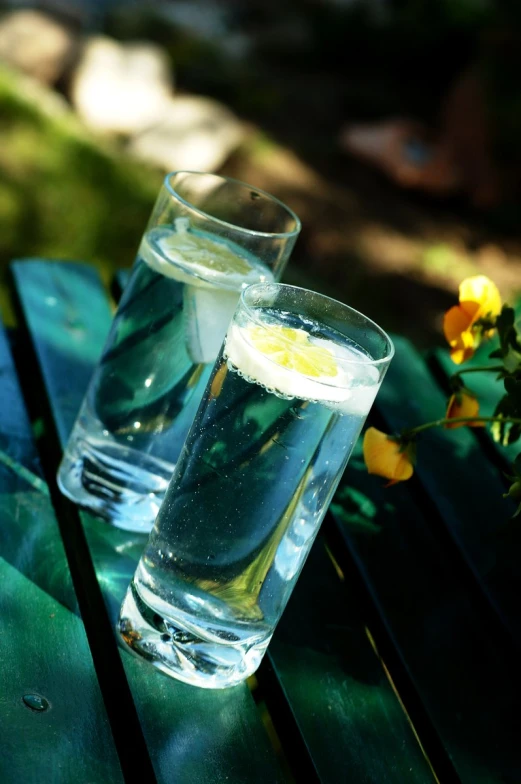 two tall, clear glasses sitting on top of a table