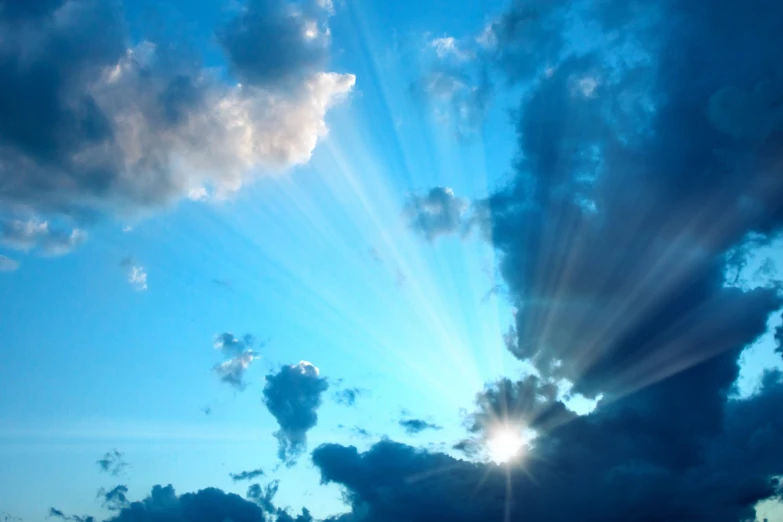 a blue sky with many clouds above and one airplane