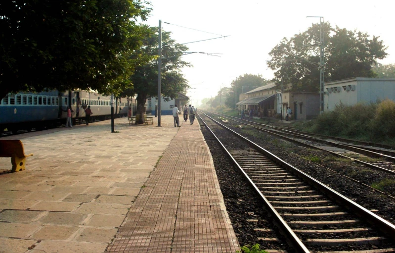 people are walking along side train tracks in the fog