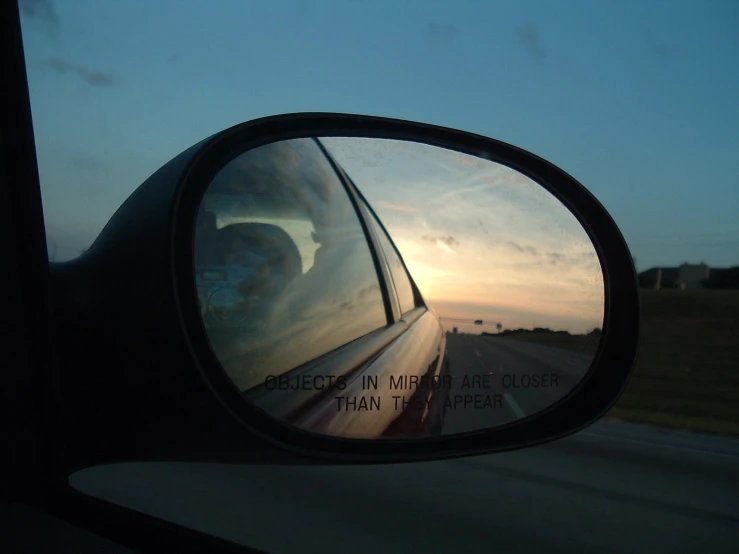 a rear view mirror is seen to the side of a vehicle