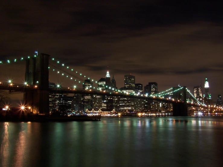 the brooklyn bridge from across the water at night