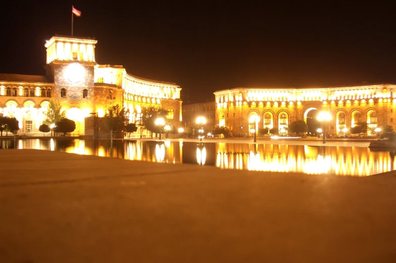 a very pretty lighted building by some water