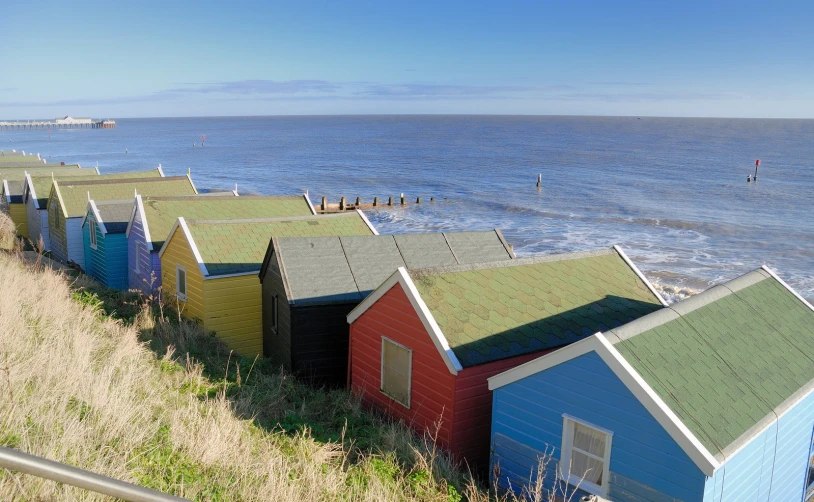 many colorful shacks on the beach near the water