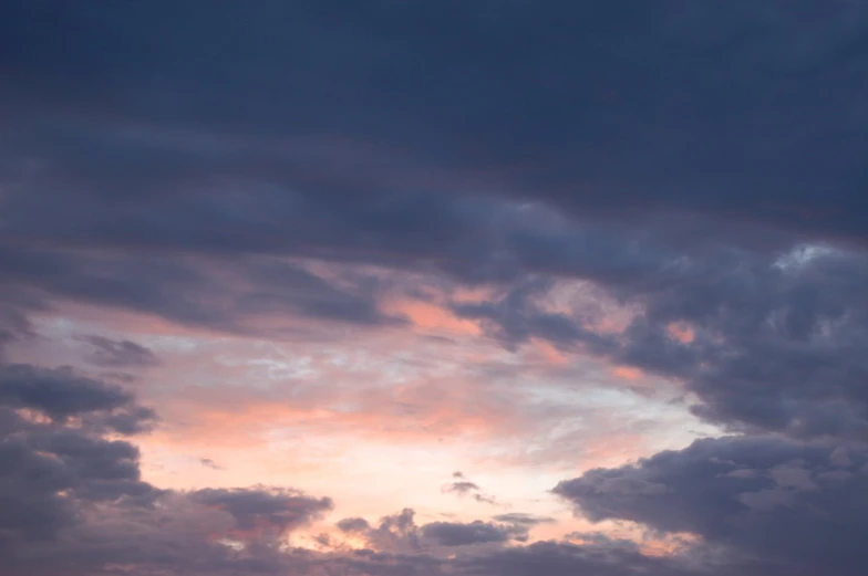 the sky is full of pink clouds on a cold evening