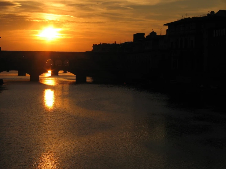 a sunset over the water near buildings