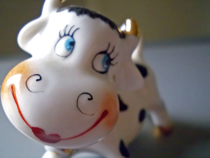 an animal figurine with blue eyes that has a brown spot