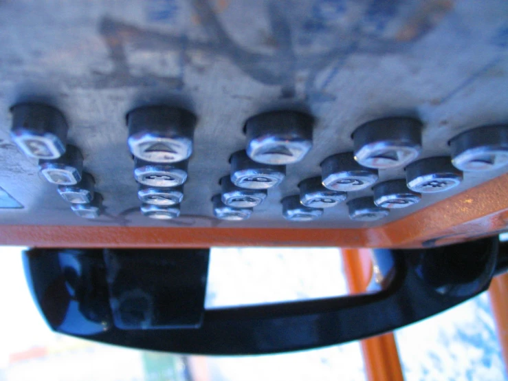 this is a closeup po of a wooden table with holes and rivets