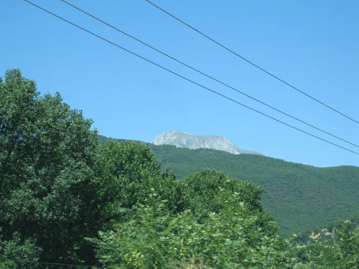 a very high mountain that is next to some power lines