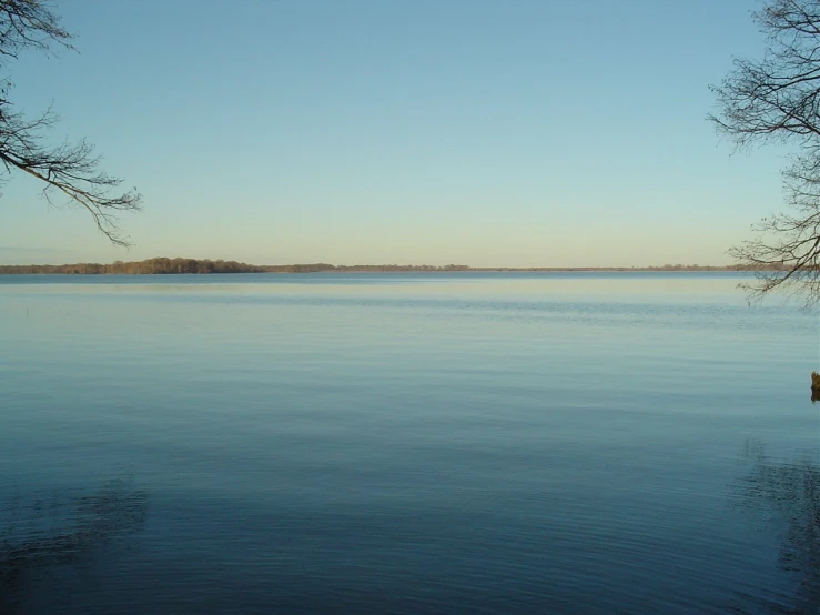 an empty calm body of water under a clear blue sky