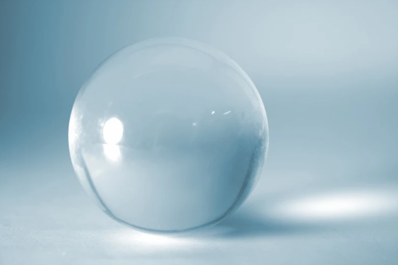 a shiny clear glass ball sitting on top of a table