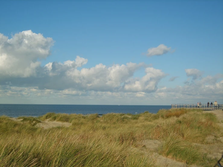 people sit on the beach under some cloudy skies