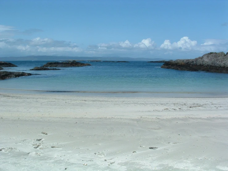 the beach has a sandy shoreline with water on it