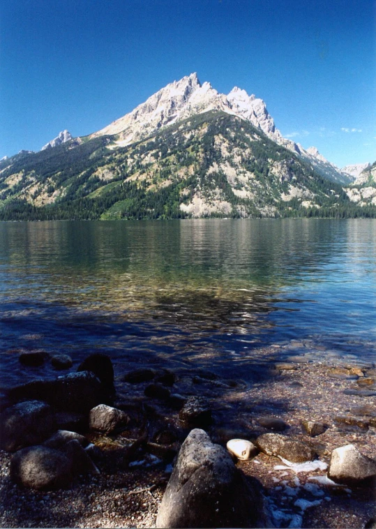 a mountain is sitting on top of a body of water