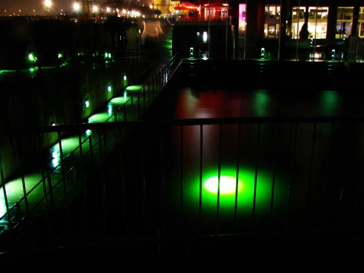 green lights in a reflecting pool at night