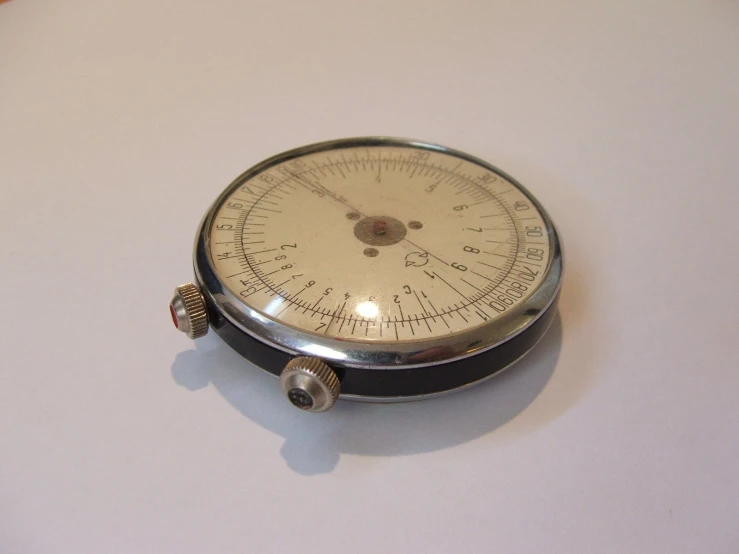 a small metal compass resting on the floor