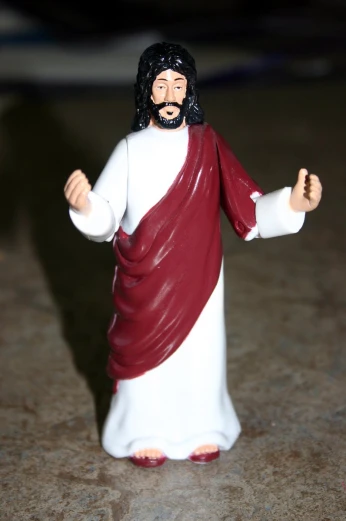 a toy jesus figure holding a cross in a room