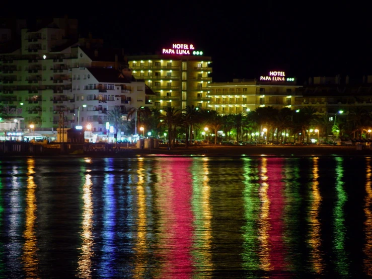 a night scene with a lit up el next to the water