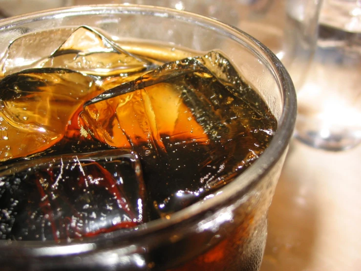 sodas and ice in a glass on a table