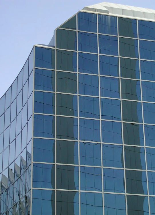 the reflection of a clock in a building's glass wall