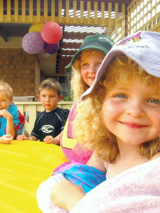 several children sitting at a yellow table