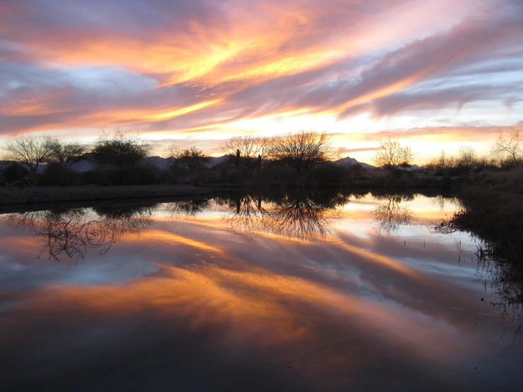 a colorful sky reflecting in the water of a lake