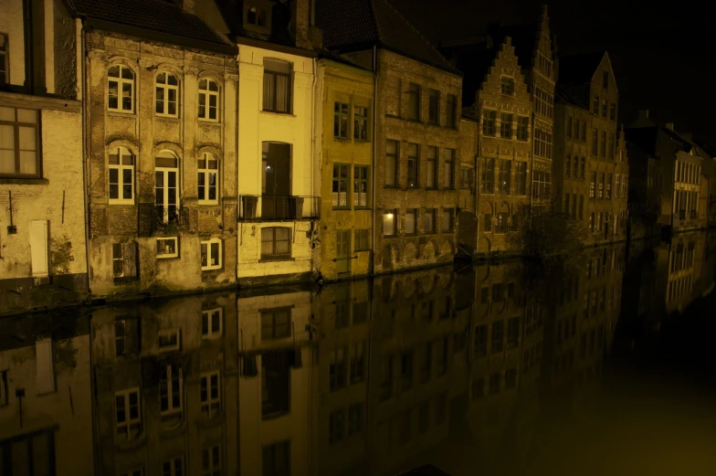 a row of buildings beside the water at night