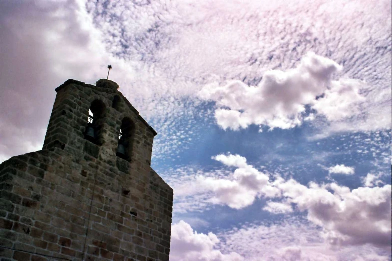 an old tower on the sky with clouds