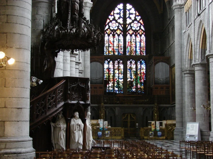 a church with multiple pews lined up next to a large stained glass window