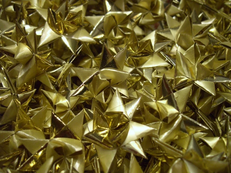 a lot of shiny metallic stars that are in a pile