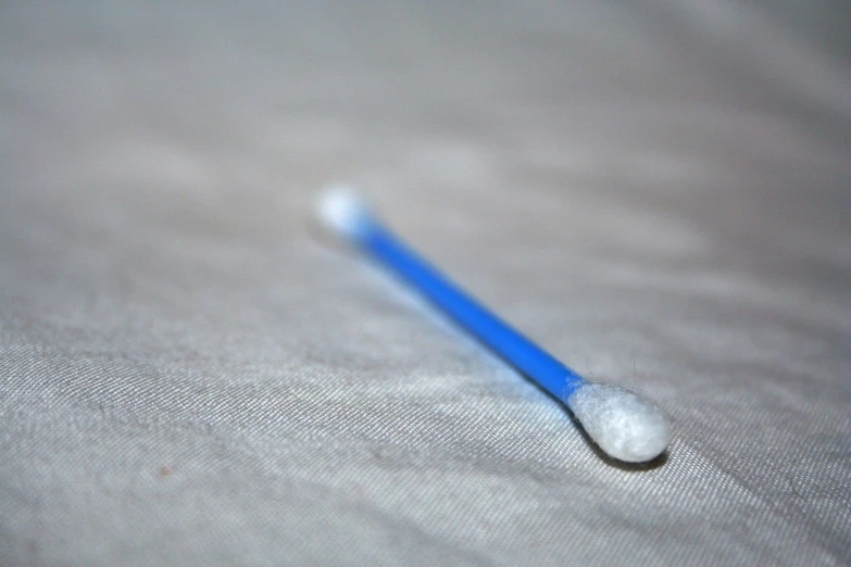 an extreme close up of a toothbrush against a linen