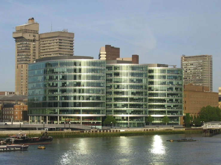 a large building sitting near the river next to other tall buildings