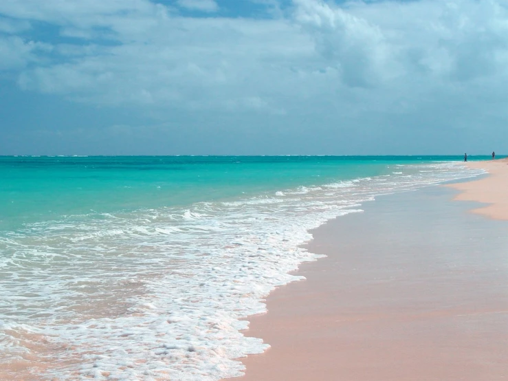 several people are walking out into the ocean from a beach