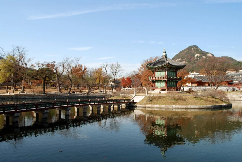 a body of water with a bridge over it and buildings in the background