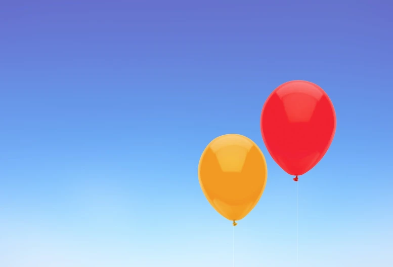 two red and yellow balloons fly in the blue sky