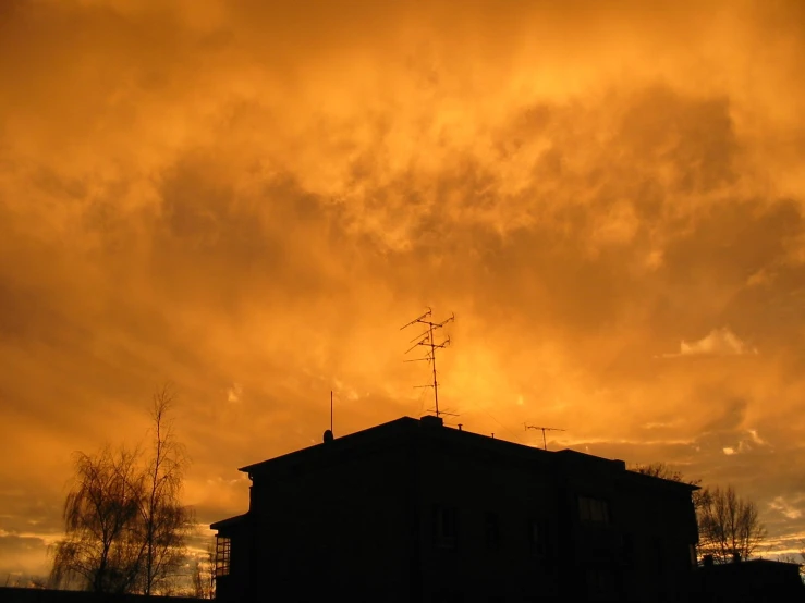 the silhouette of a building against an orange sky