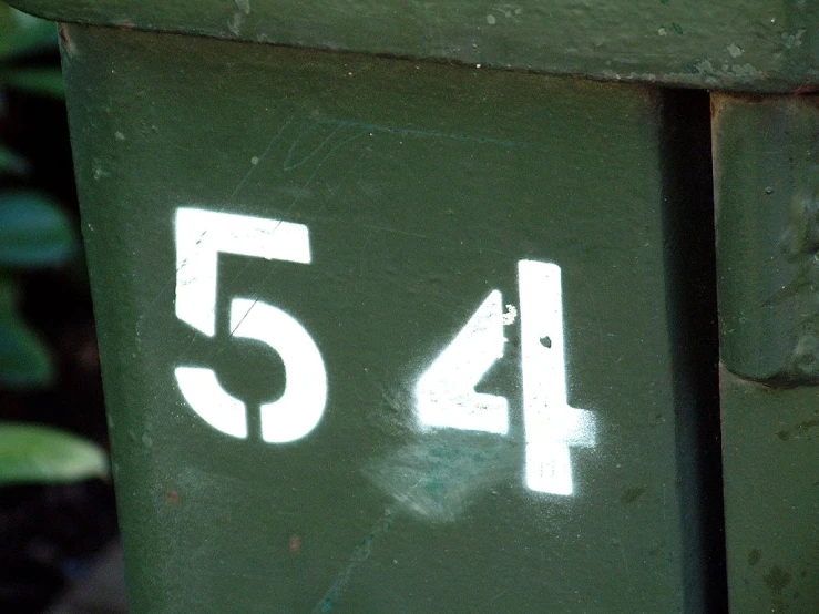a close up view of a green bin with graffiti on it