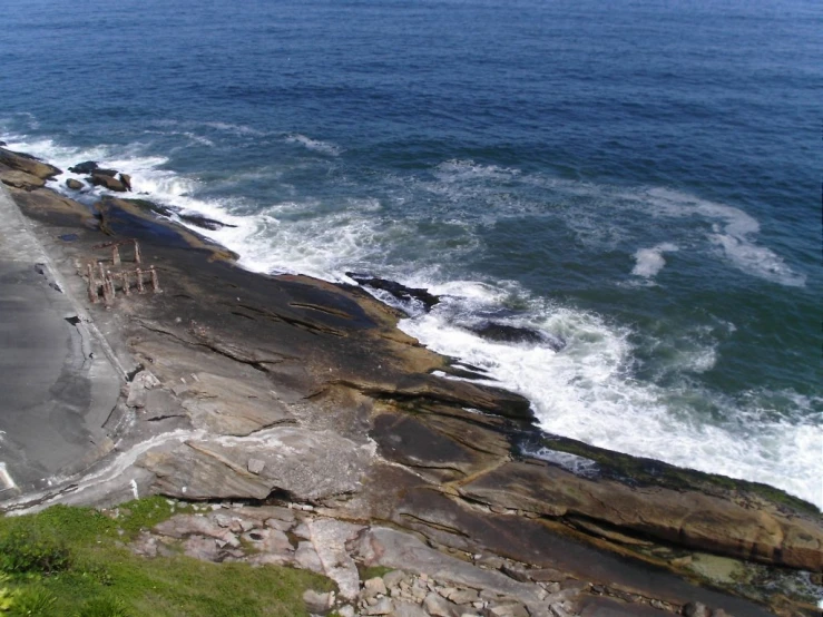 the coast is rocky with several people walking on it