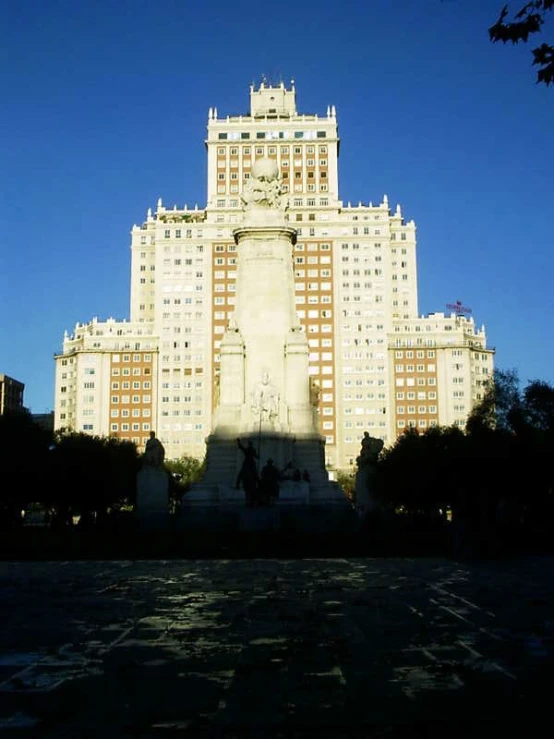 an ornate building with a tower stands against a bright blue sky