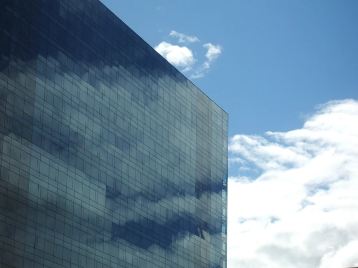 a high rise building has a large cloud in the sky