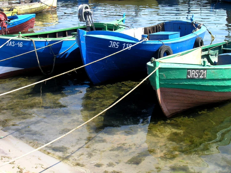 three boats docked together in the water at the harbor