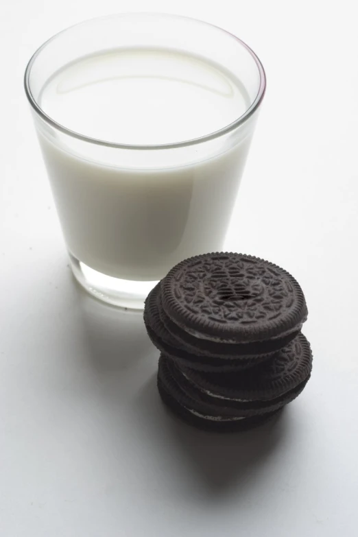 a glass of milk next to a stack of cookies