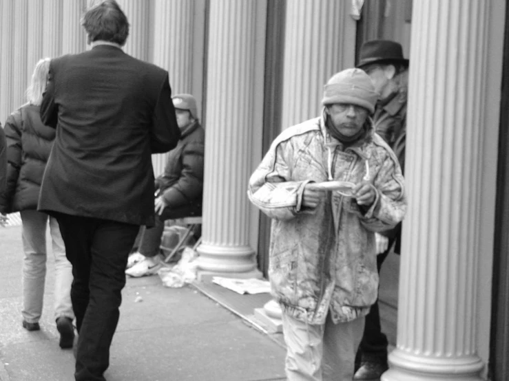 a man in a leather coat is walking near a building