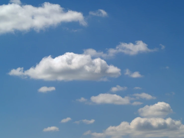 an airplane flying overhead with a blue sky in the background